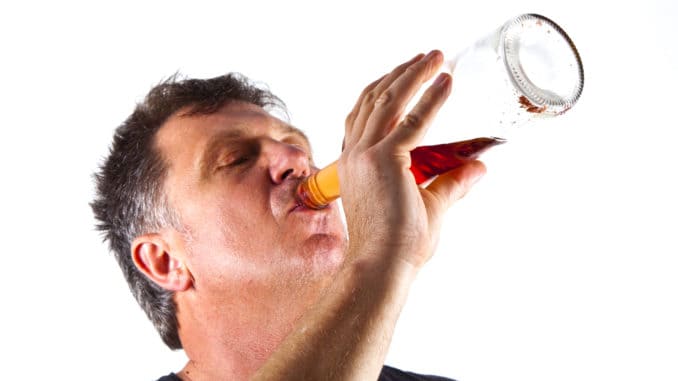 Man drinking alcohol out of a bottle