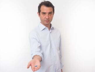 Man showing a bunch of medicine pills in his hand