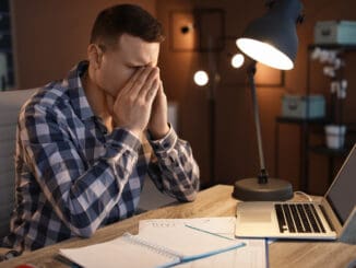 Overworked man with headache in office