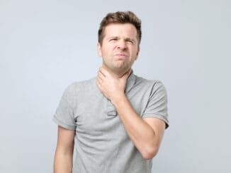 Young man with throat pain feeling ill.