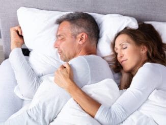 Mature Loving Couple Sleeping On Bed With White Blanket