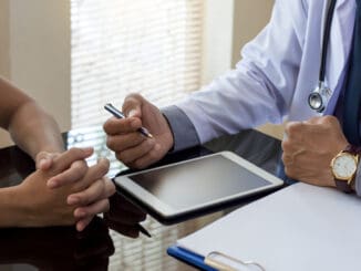 physician talking to patient with digital tablet