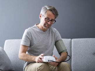 Elder Man Checking Blood Pressure At Home