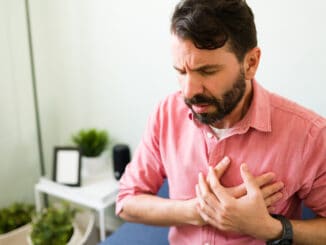 Handsome man in his 30s at home having a heart attack