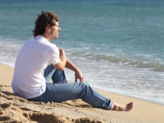 Man thinking and watching the sea on the beach