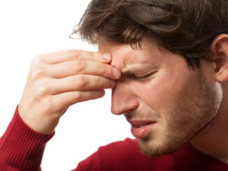 Man holding his nose because of a sinus pain