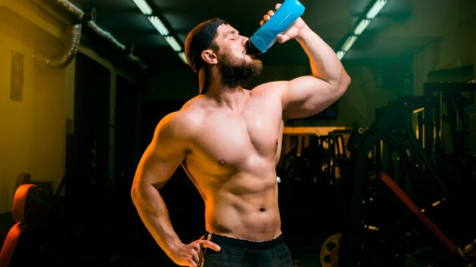 Man in the gym drinking from the shake