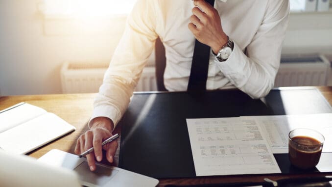 Business man working at office with laptop and documents on his desk