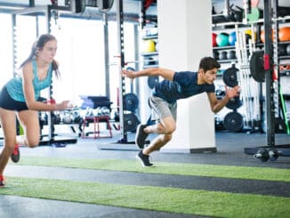 Young fit couple in gym fast running.